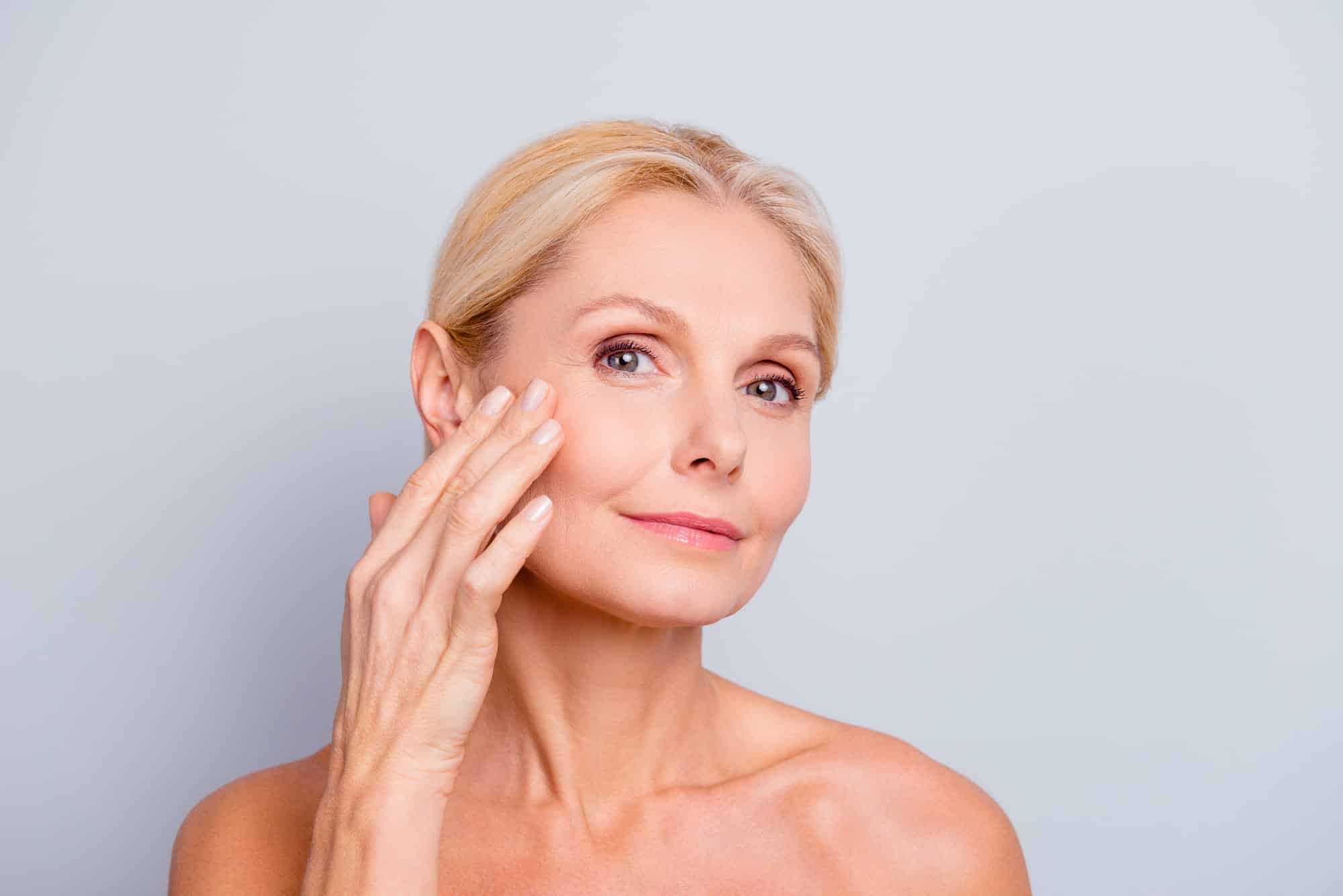 a woman examining her face after a skin lift treatment