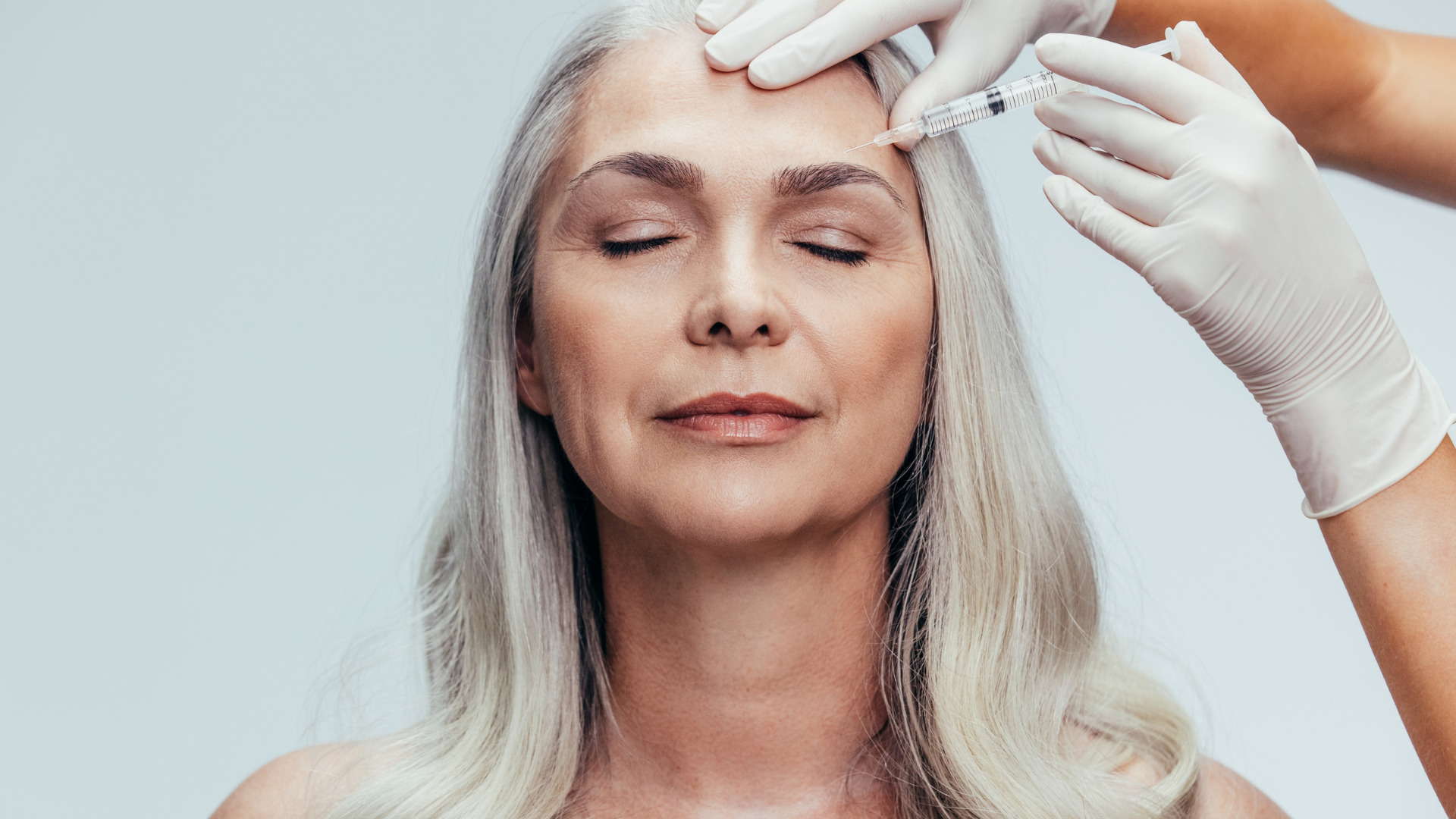 An older individual undergoing a Botox injection on their forehead.