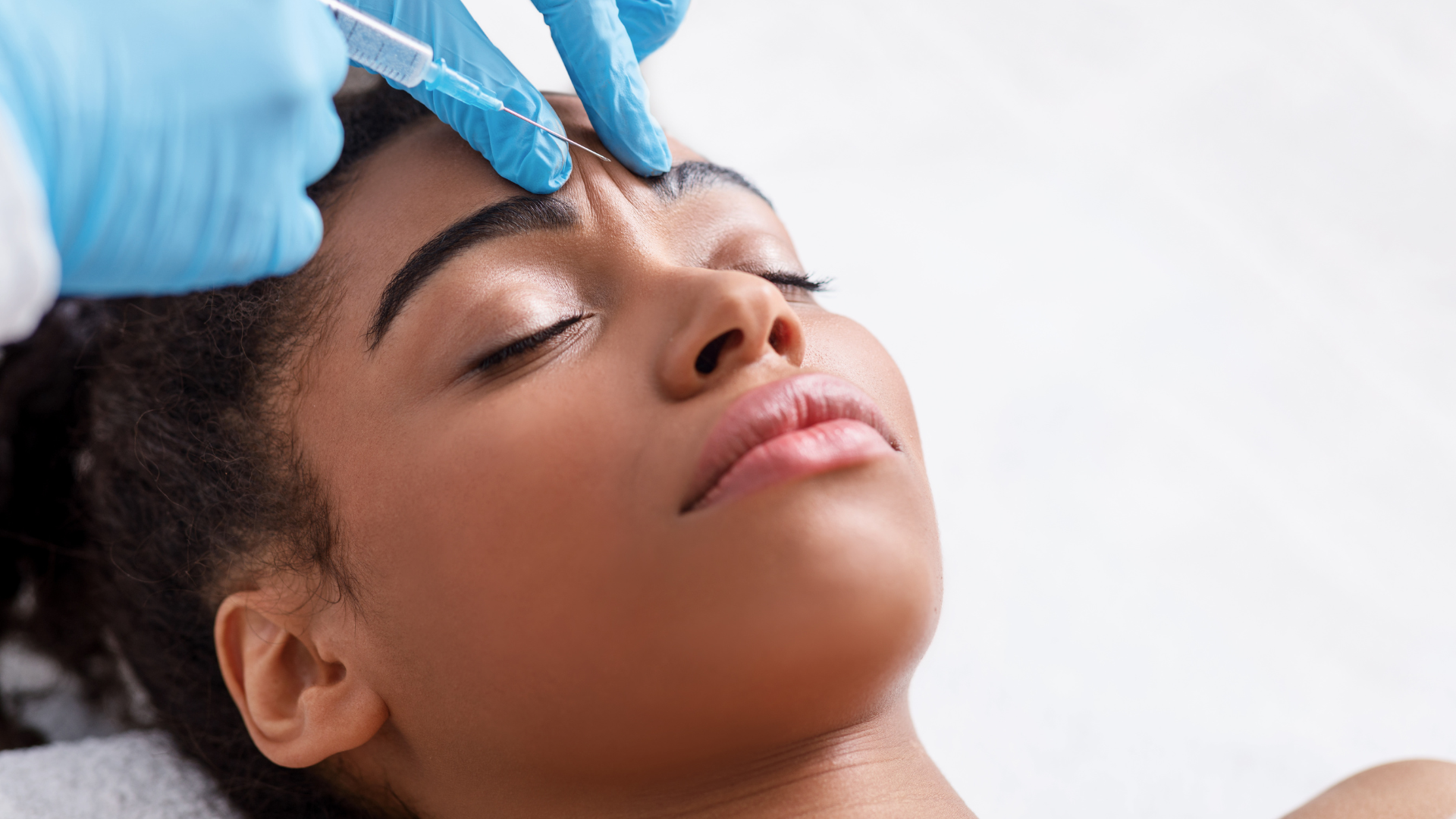 An individual getting a Botox injection to treat their glabellar lines.