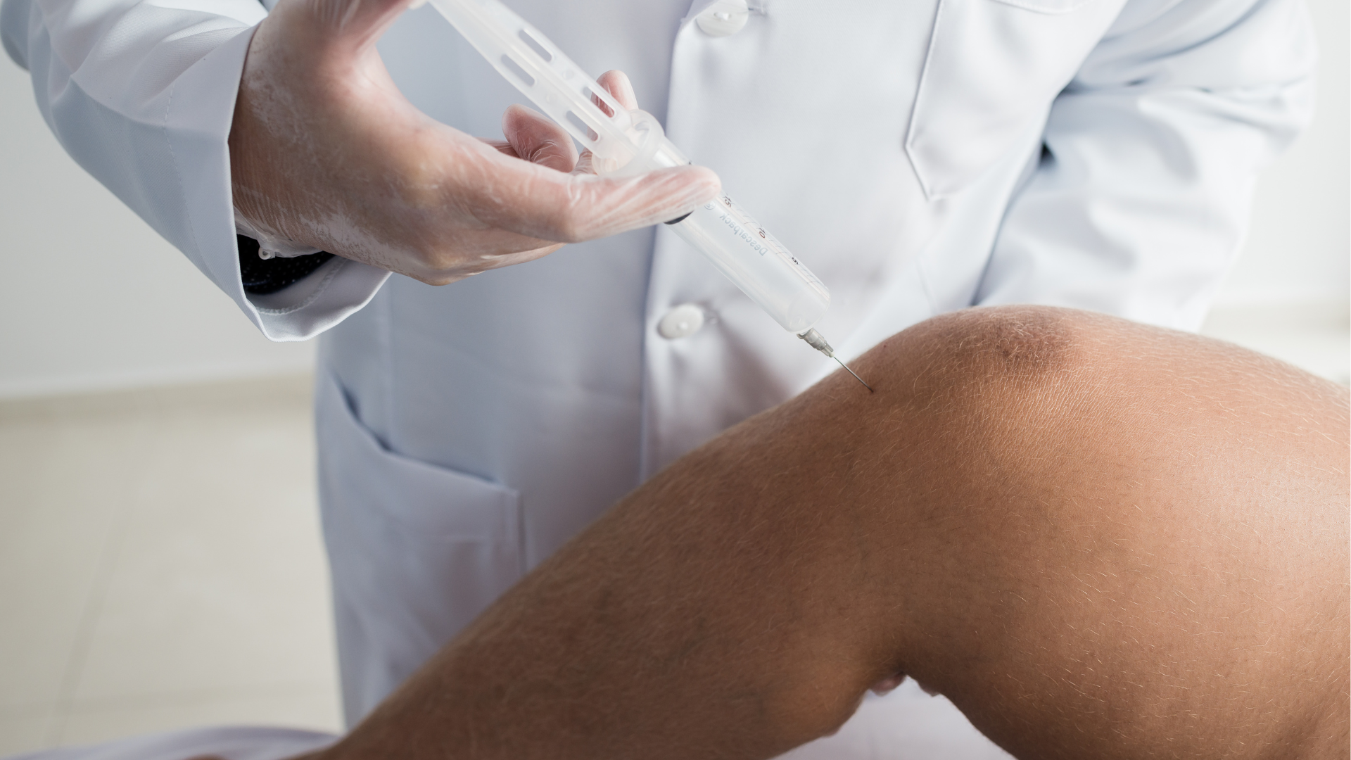 A healthcare provider administering a knee injection.