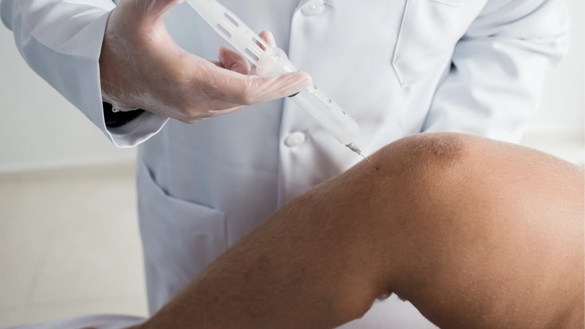 A healthcare provider administering a knee injection.