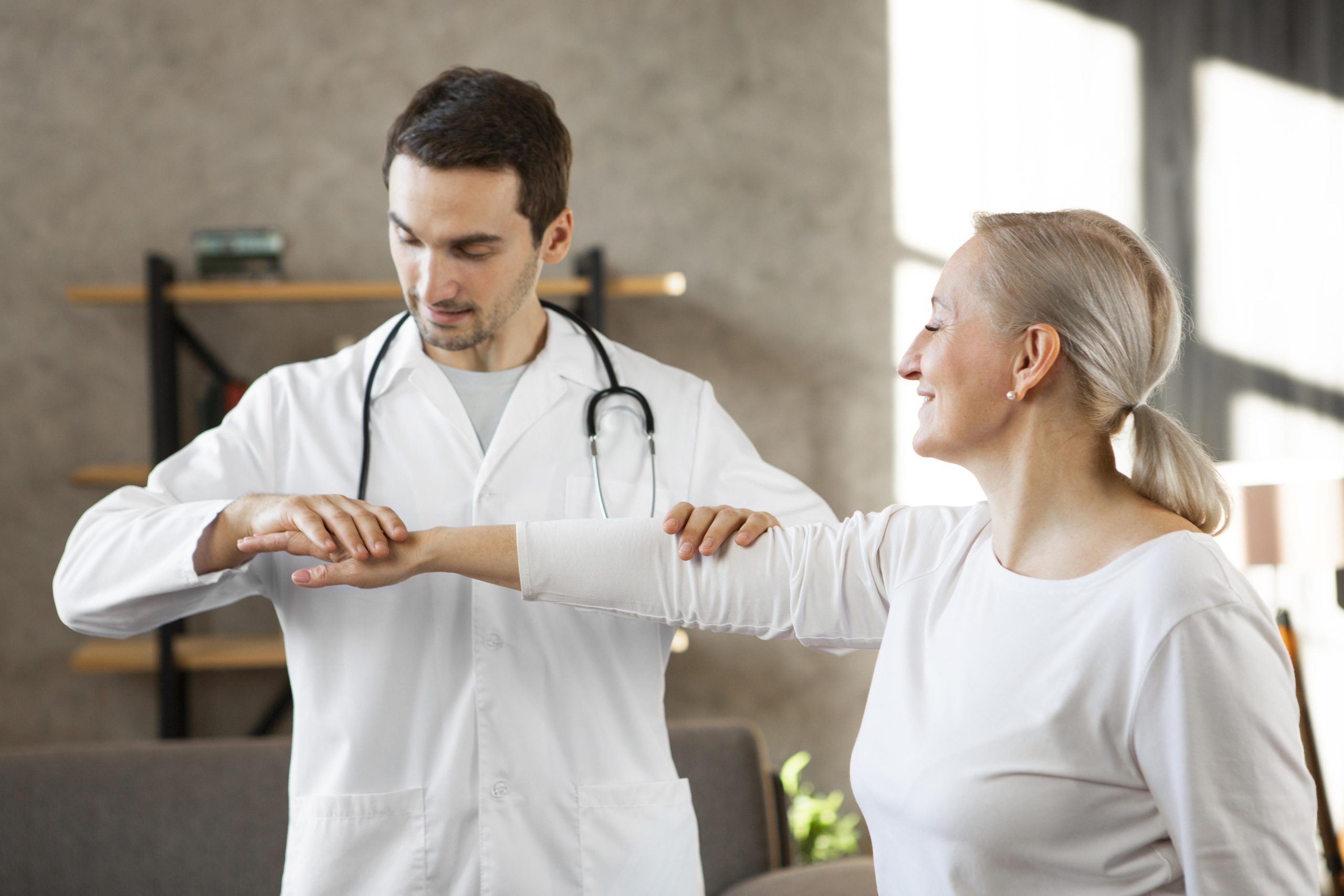 A medical professional examining a patient's shoulder movement.