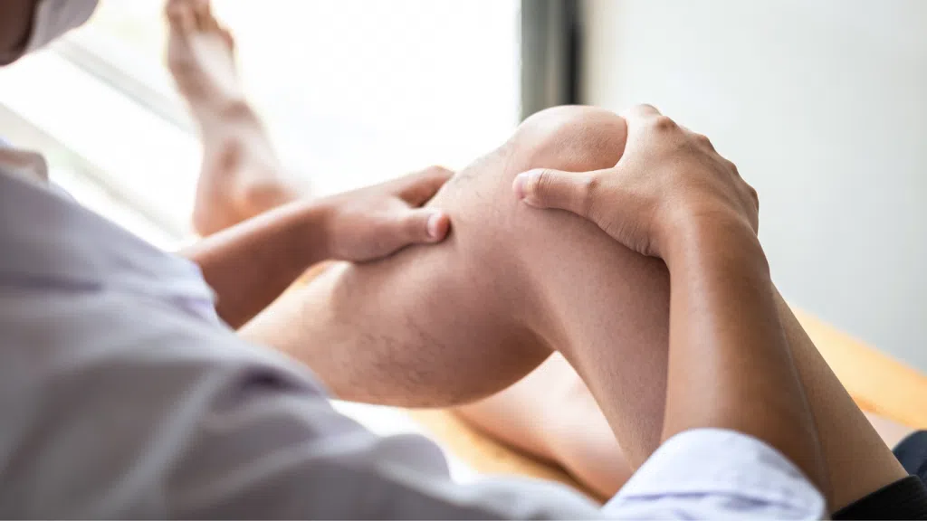 A healthcare provider examining the patient's knee.