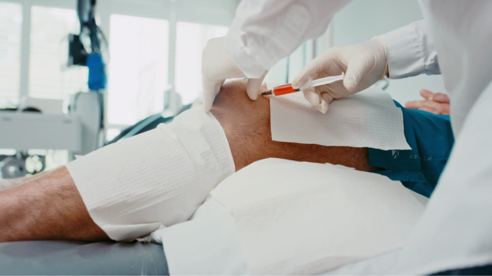 A medical professional administering a knee injection.