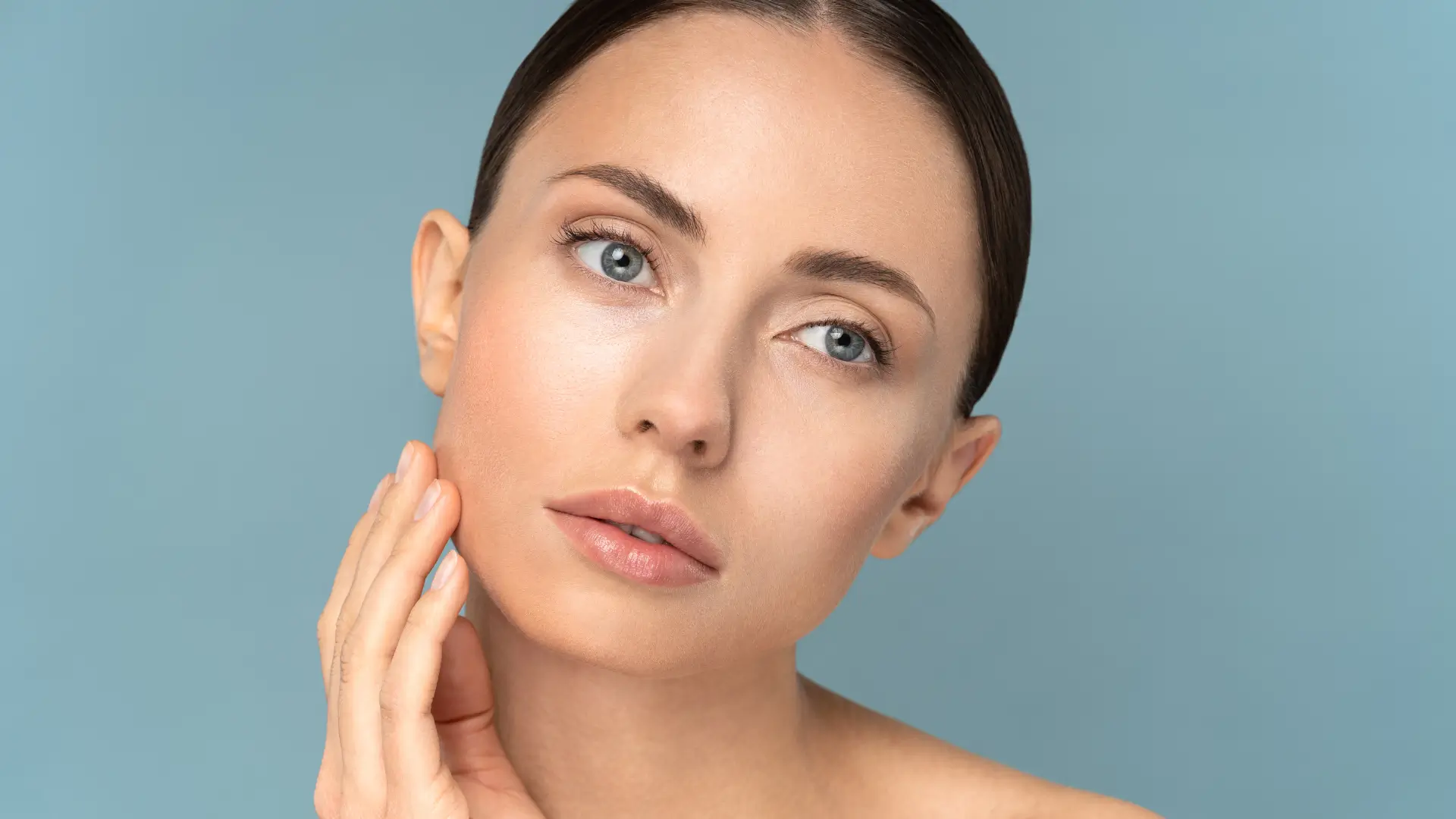 An individual flexing their rejuvenated facial skin.