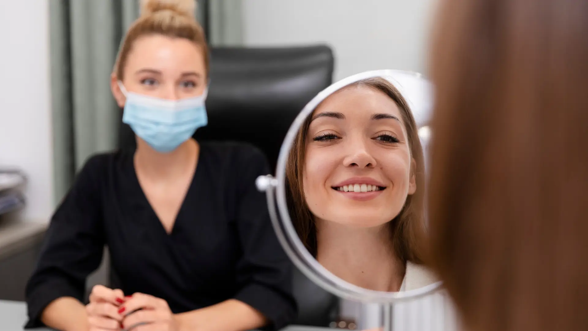 A patient looking in the mirror during a consultation with their doctor.