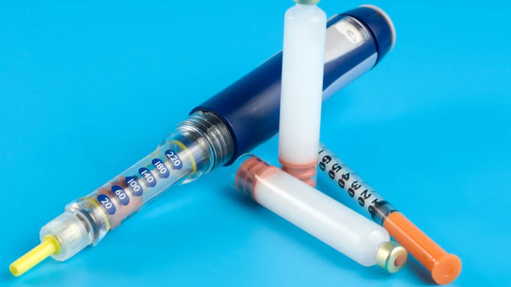 A close-up shot of an injectable pen and medical syringe.