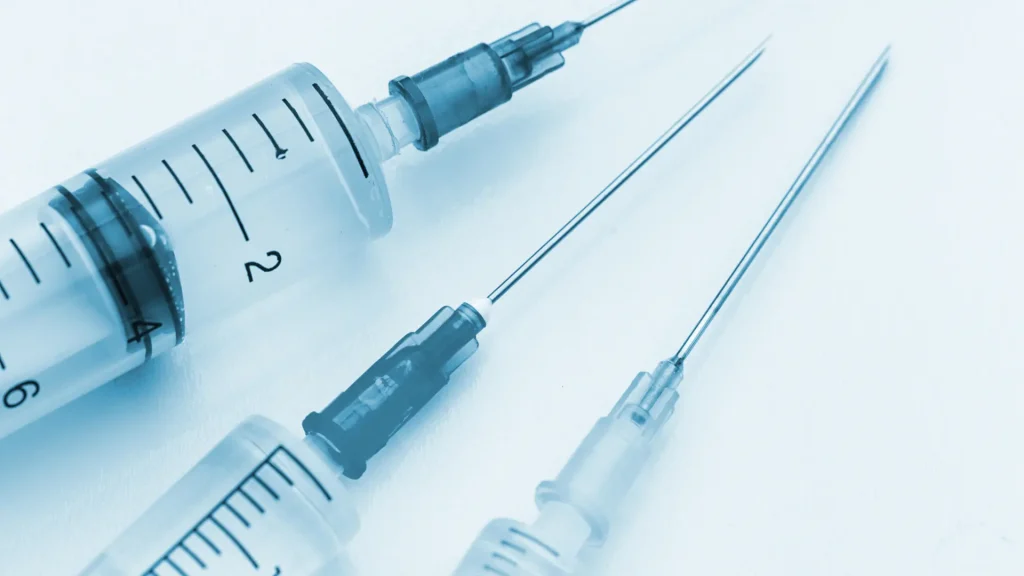 Three different medical syringes on a surface.