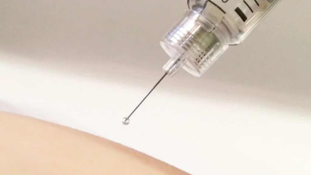 A close-up shot of a needle before injecting into the skin.