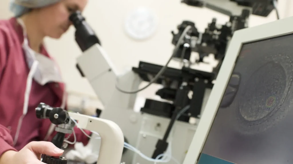 A medical expert looking at a solution under the microscope.