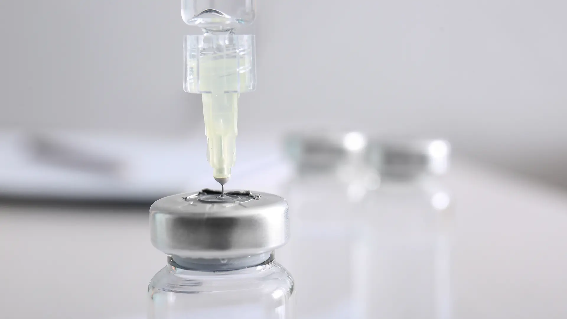 An expert transferring the vial's contents to the medical syringe.