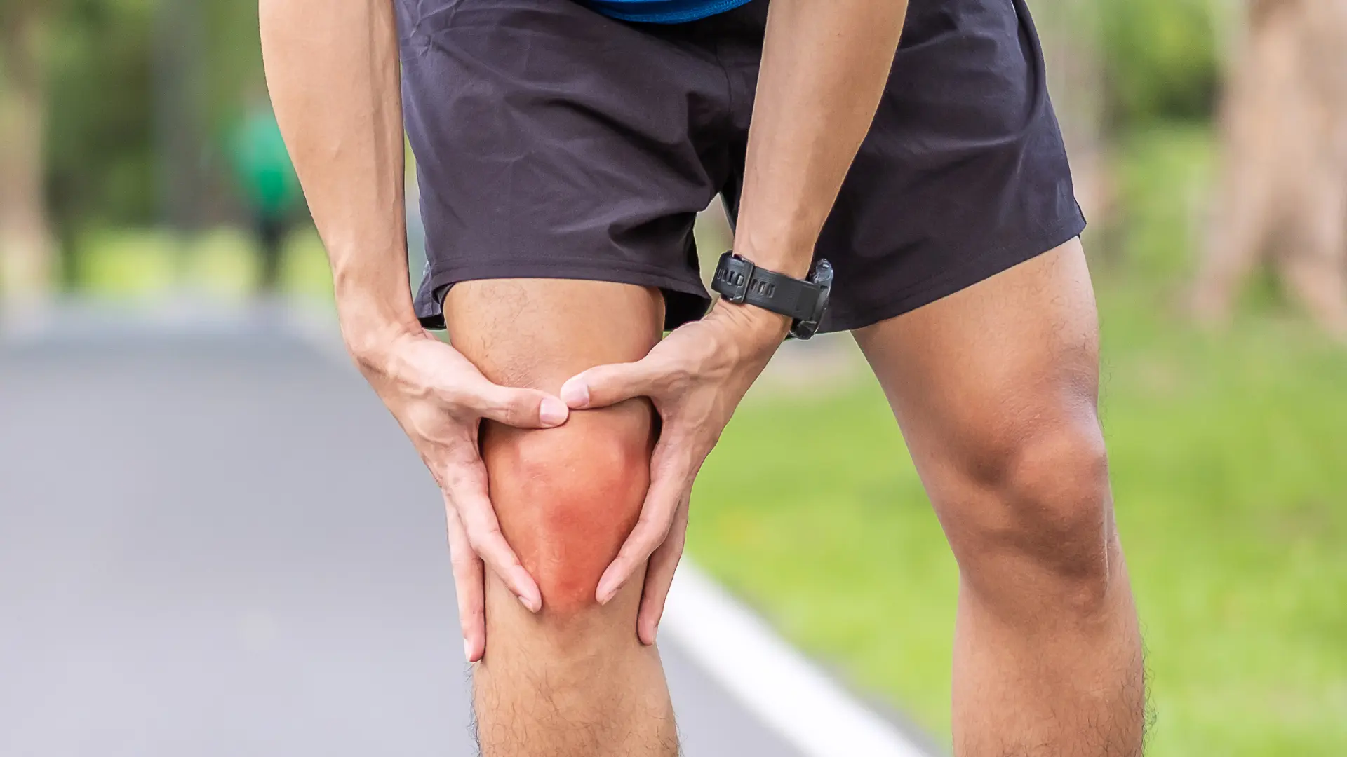 An individual suffering from knee pain while walking.