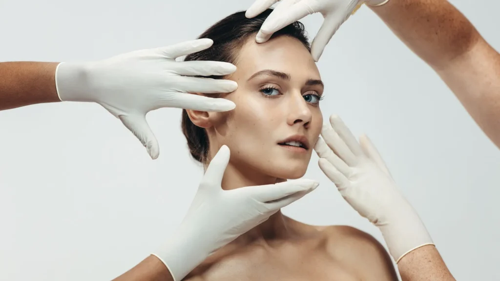 Medical professionals holding a patient's face.