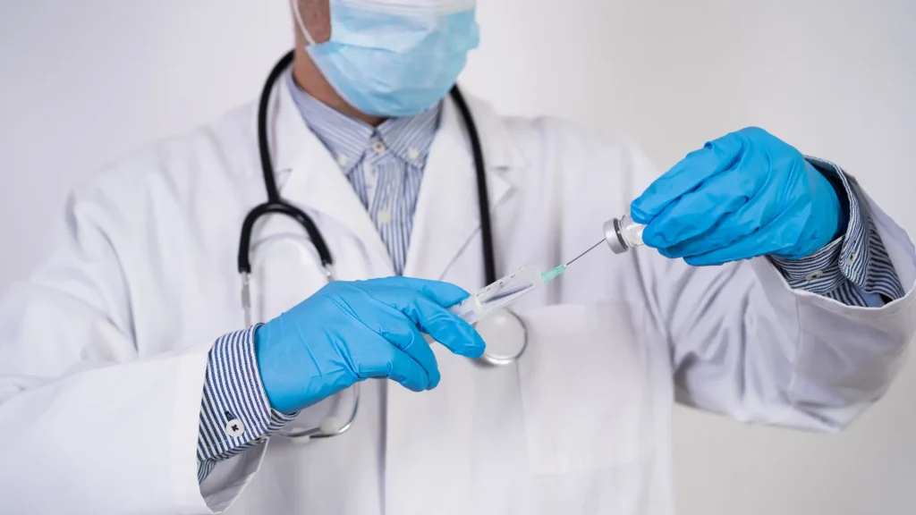 A medical professional transferring the solution into the syringe.