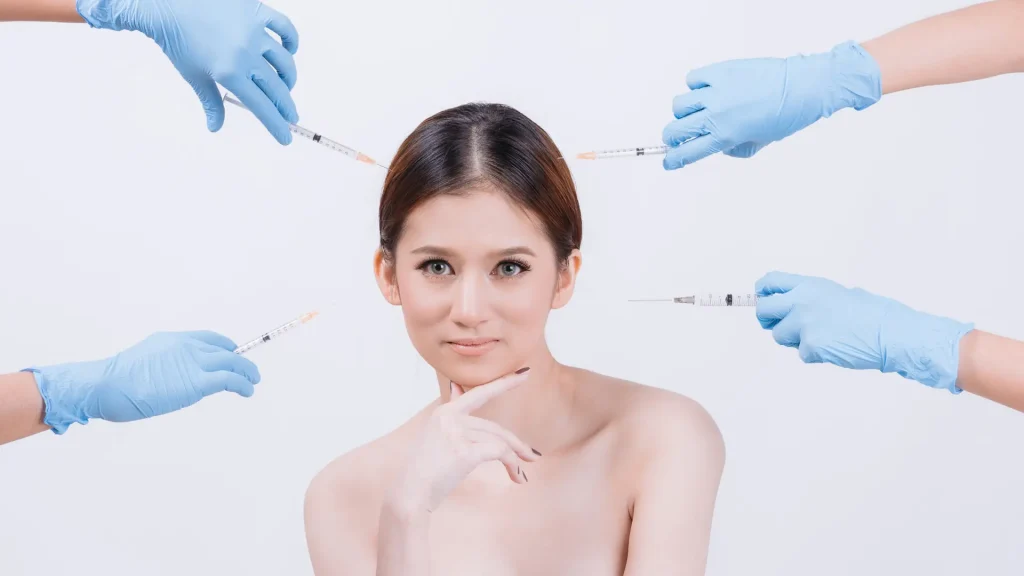 An individual in the middle of four medical professionals holding injections.