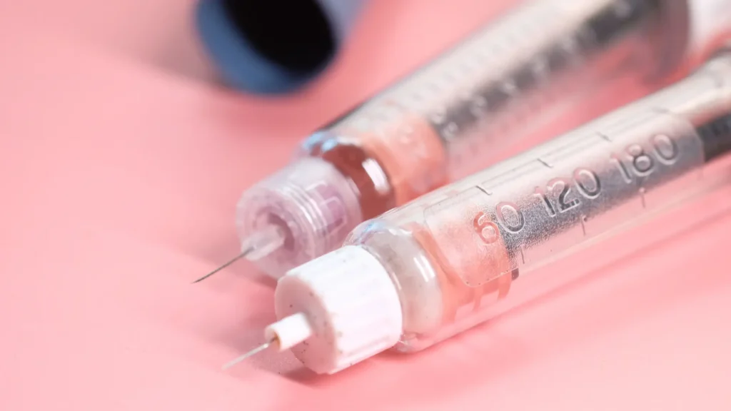 Two injectable pens closely laid on a surface.