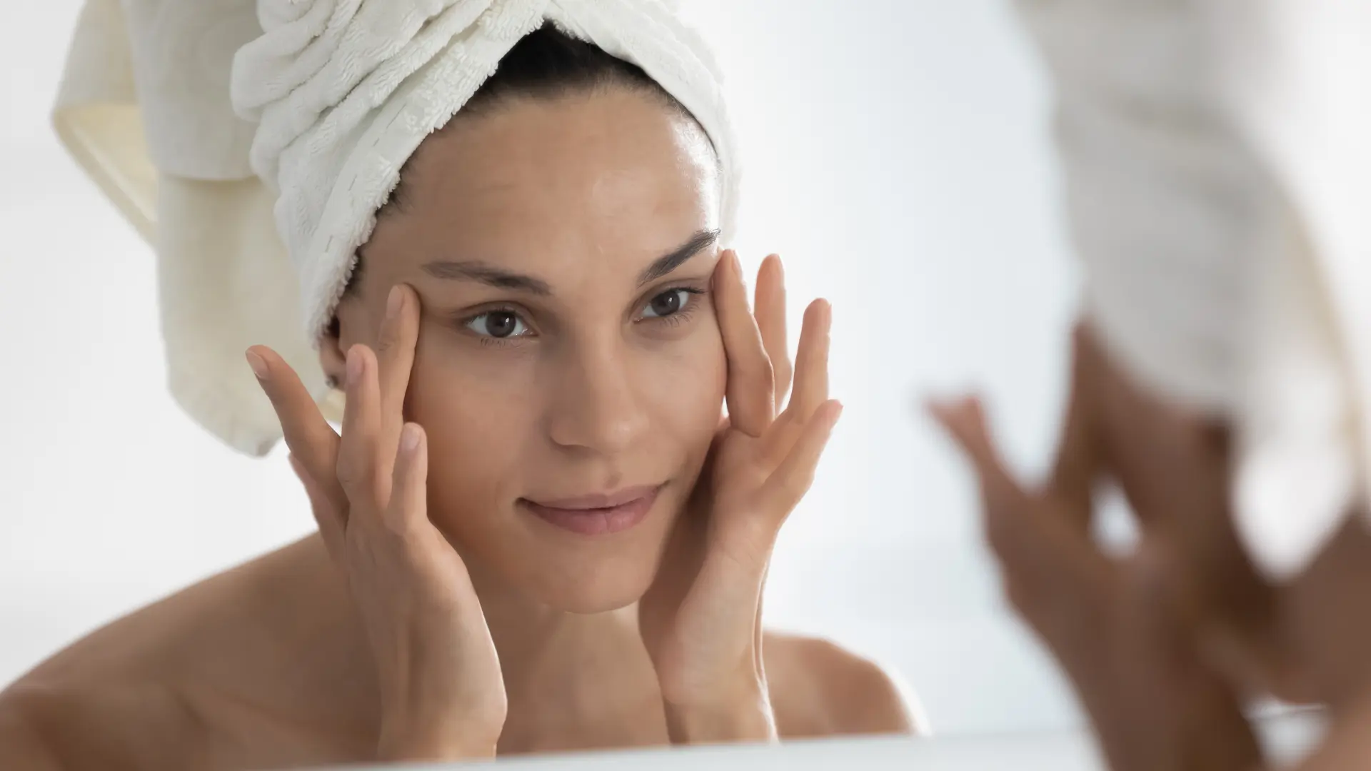 An individual checking their eye area in the mirror.