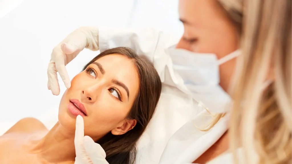 An individual undergoing a facial evaluation with a medical professional.