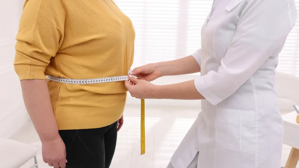 An individual consulting a medical professional for their weight-related treatment.