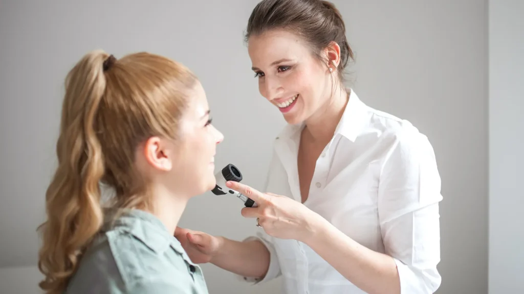 A doctor examining a patient's facial region.