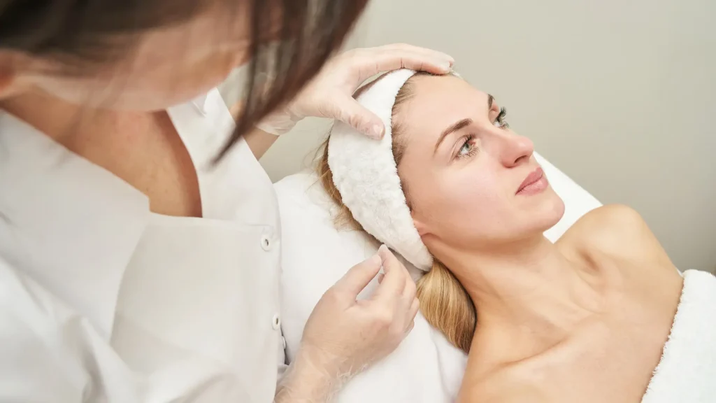 A medical professional examining the facial regions of the patient.