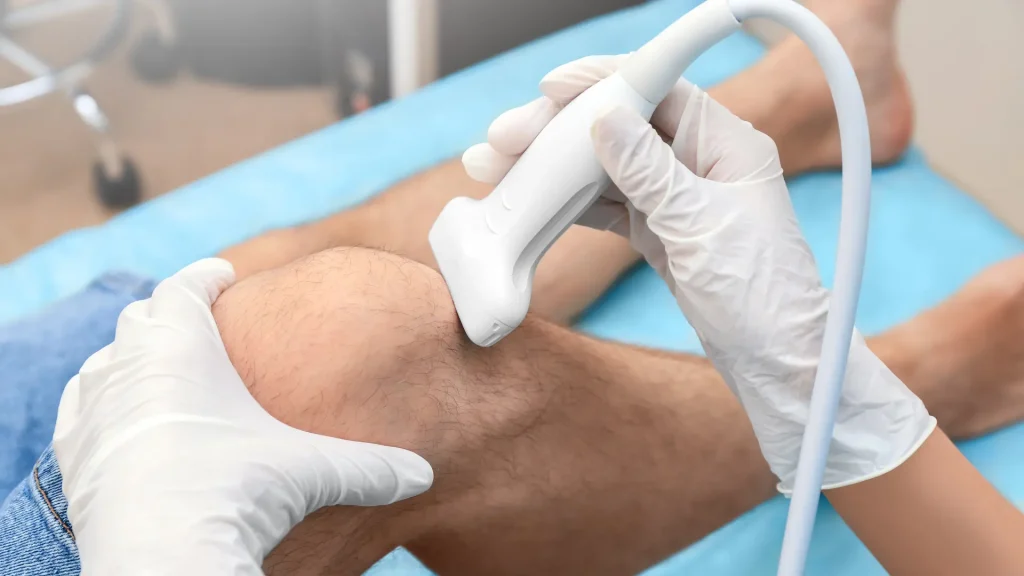 A medical professional examining a patient's knee.