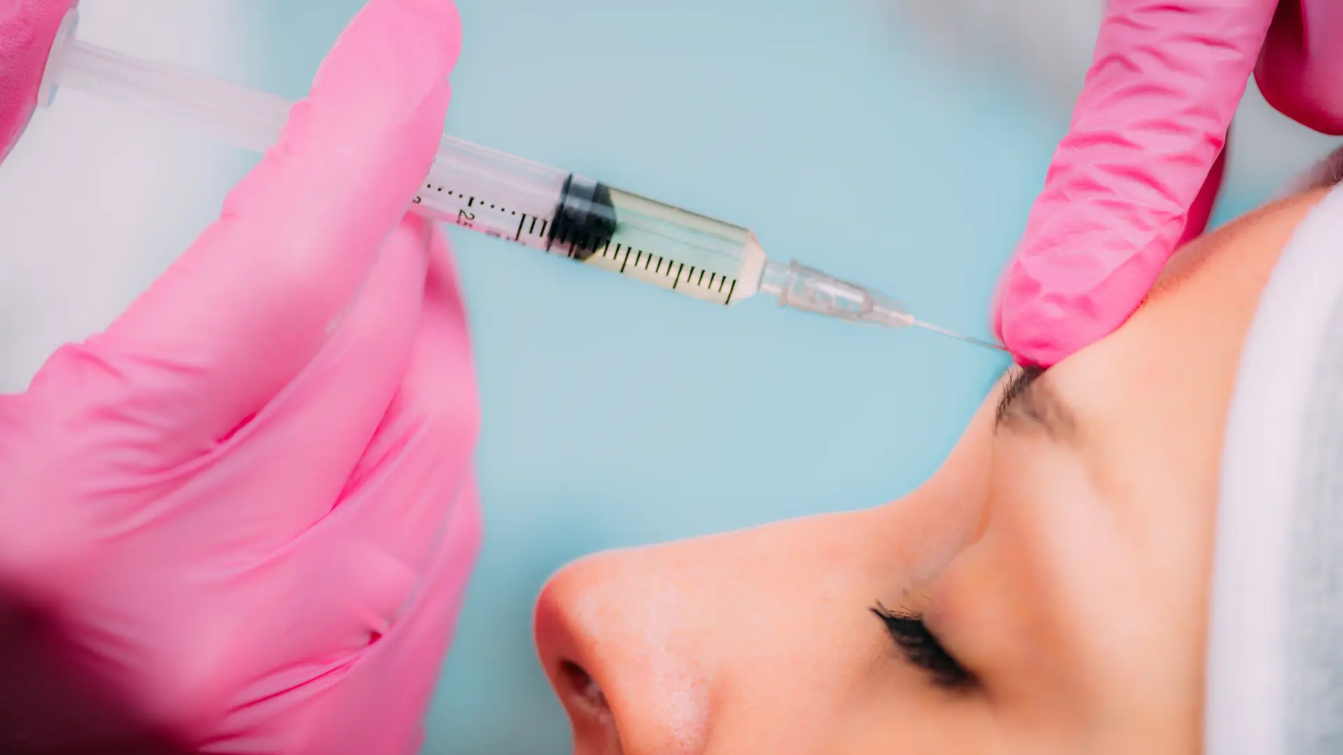 A medical professional administering an injection into a patient's '11' lines.