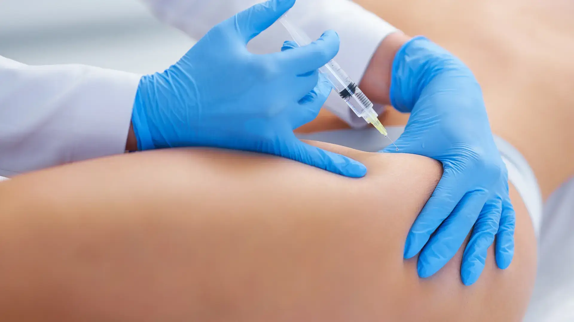 A medical professional administering an injection into the patient's hip dips.