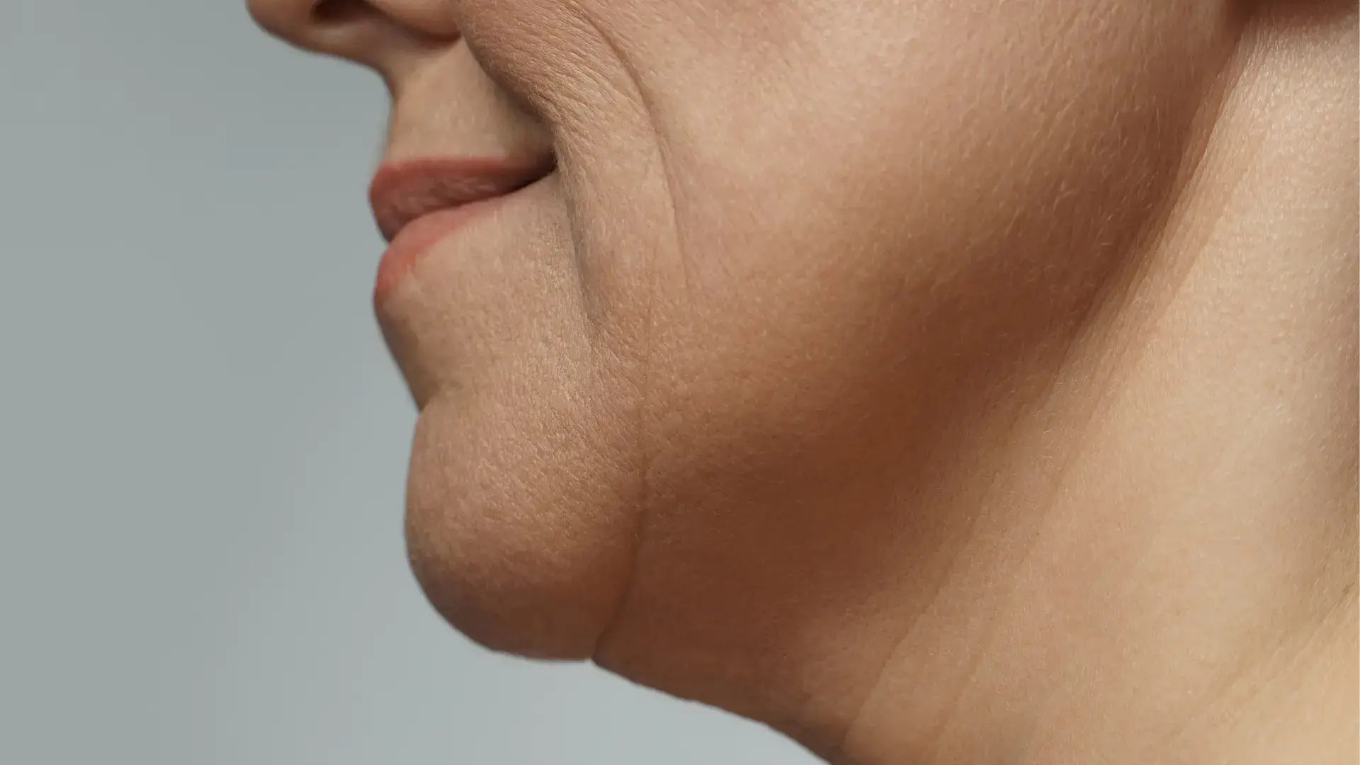 An older individual's close-up shot of their lower-face region and jawline.