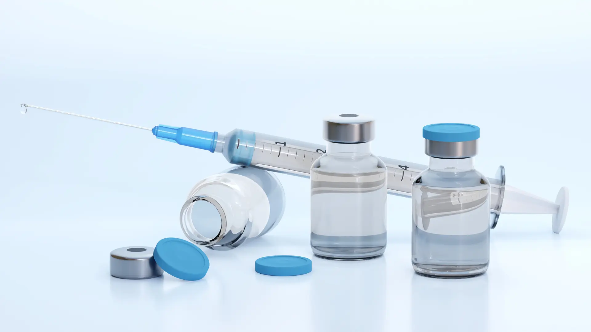 Medical syringe and vials on a surface.