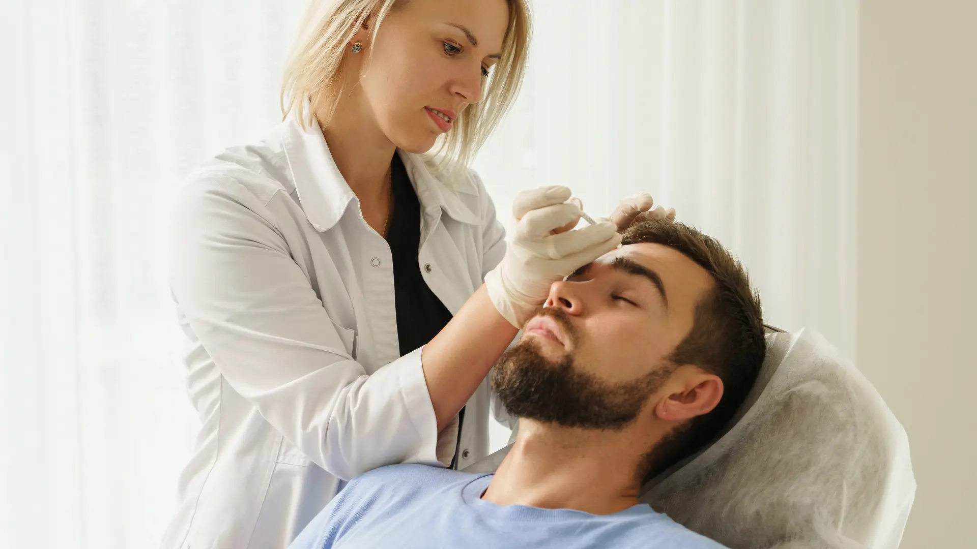 A medical professional injecting into the patient's facial region for aesthetic improvements.