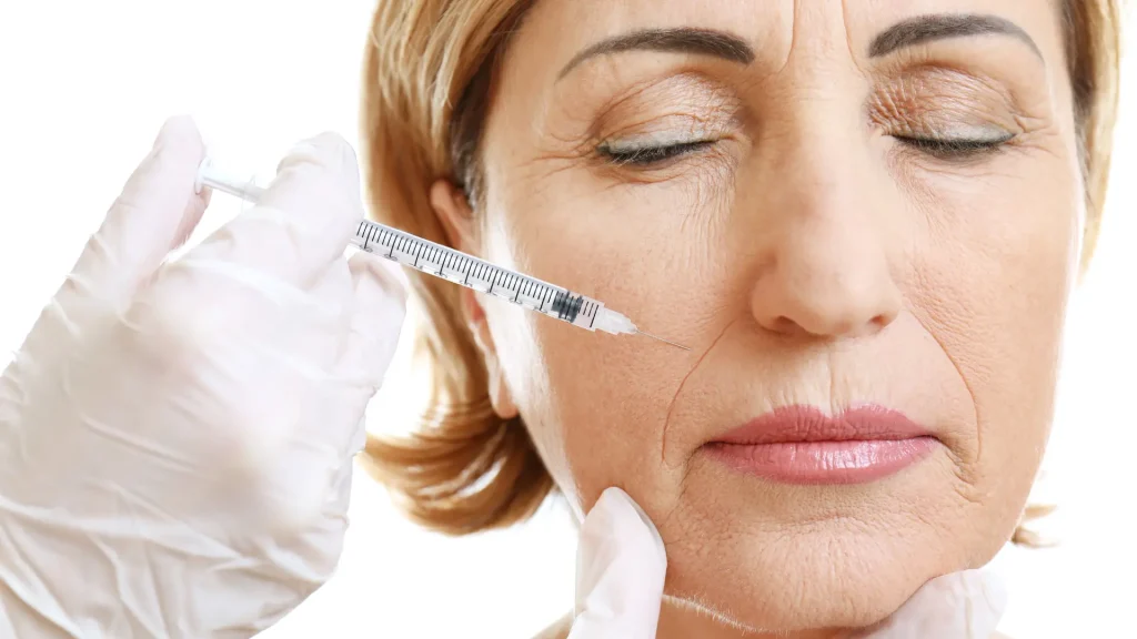 An older individual receiving injections into their nasolabial folds.