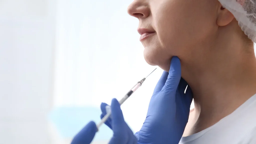 A medical professional administering an injection into their double chin.