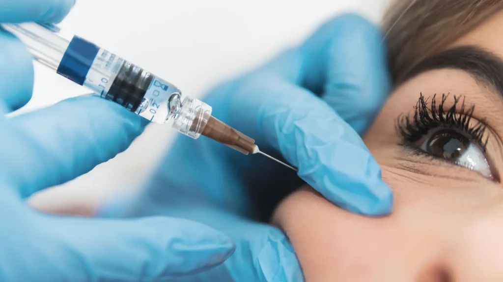 A medical professional administering an injection to the patient's cheek area.