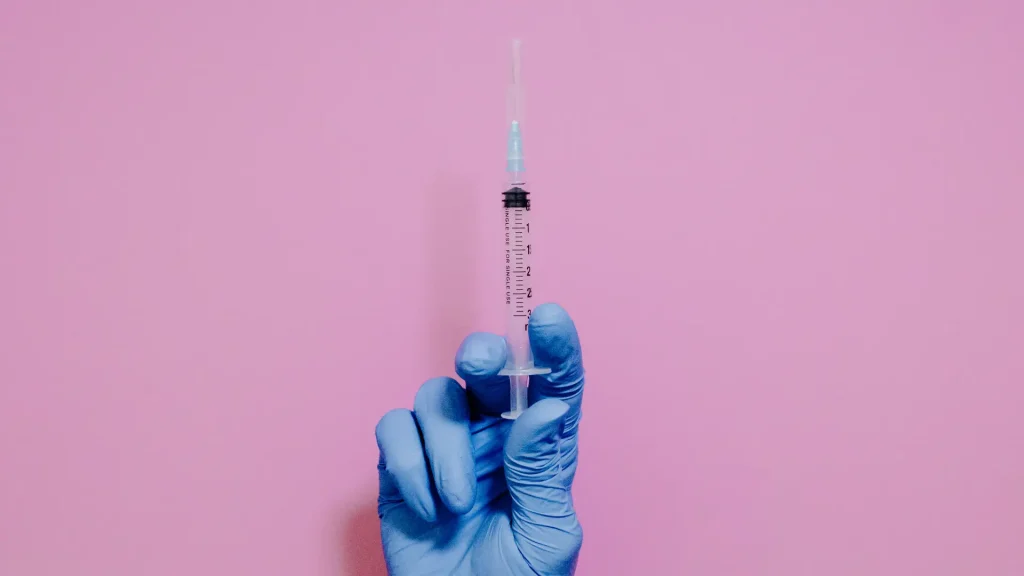 A medical professional holding a syringe.