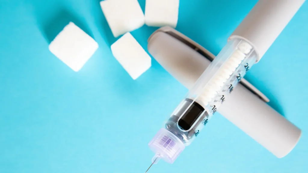An injectable pen on a blue surface.