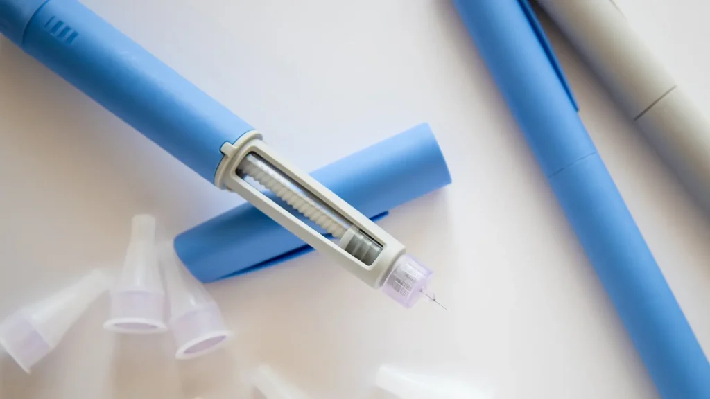 A close-up shot of an open-cap injectable pen. 