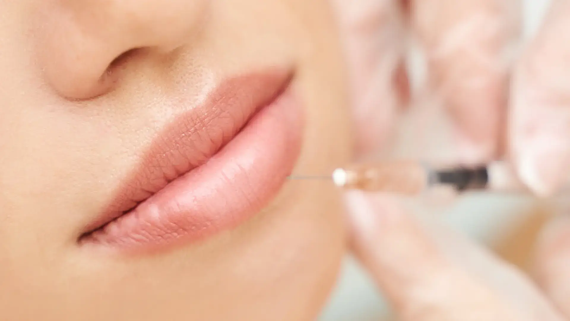 A close-up shot of a patient's lip during injection procedure.