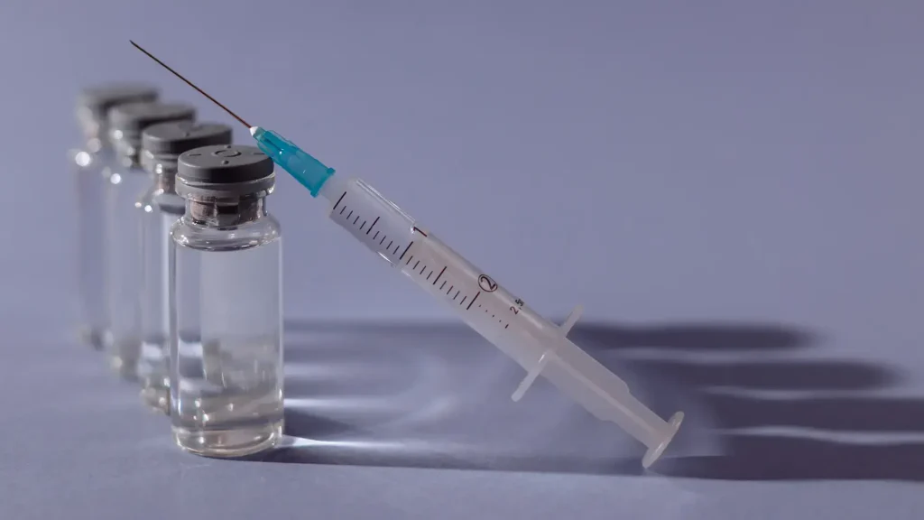A close-up shot of solution vials and a medical syringe.