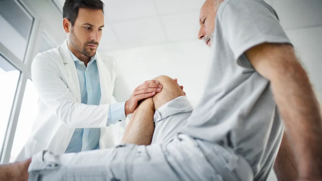 A practitioner examining a patient's knee.