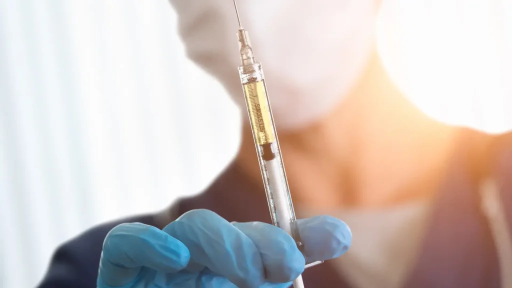 A close-up shot of a medical professional holding an injection.