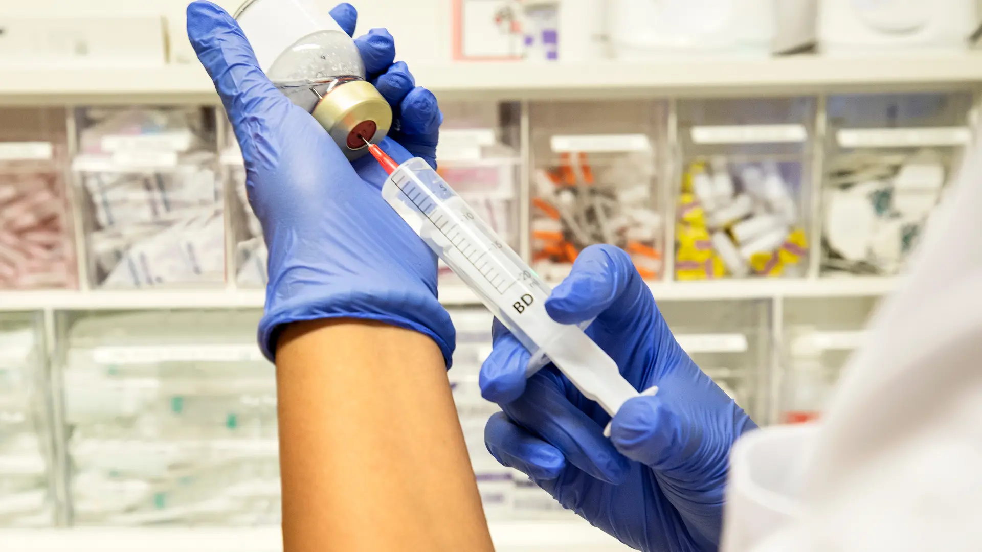 A medical professional preparing a medical injection.