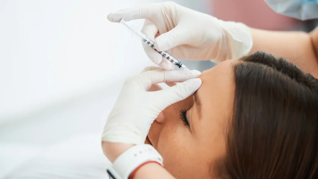 A medical provider administering an injection into the individual's glabellar lines.