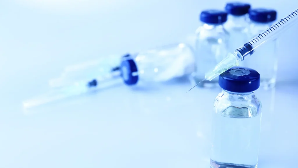 A close-up shot of vials and a medical syringe.