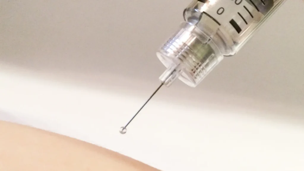 A close-up shot of an injection into the skin.