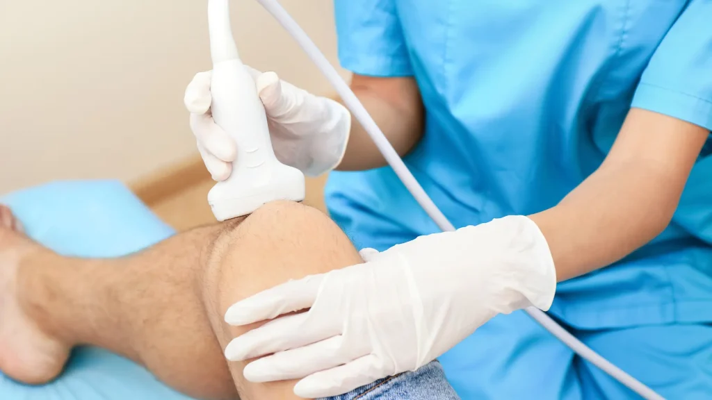 A medical professional examining a patient's knee.