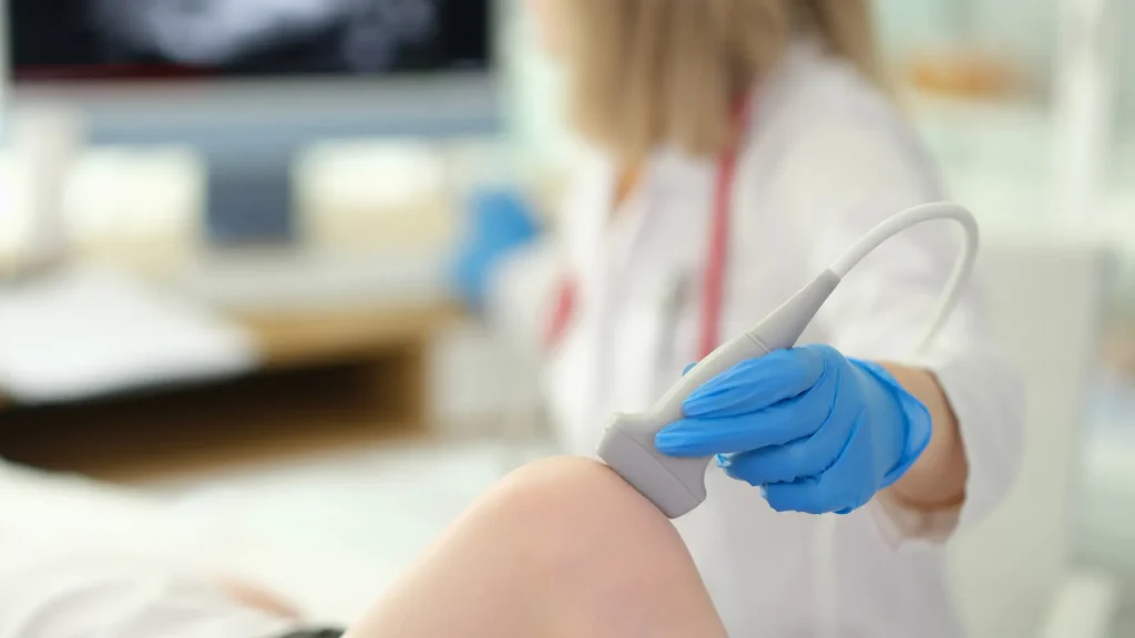 A medical professional performing a knee examination.