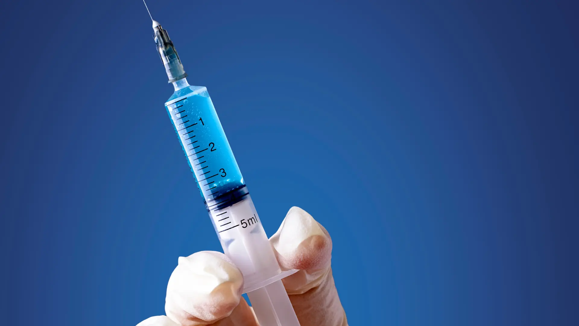 A medical professional holding a syringe.
