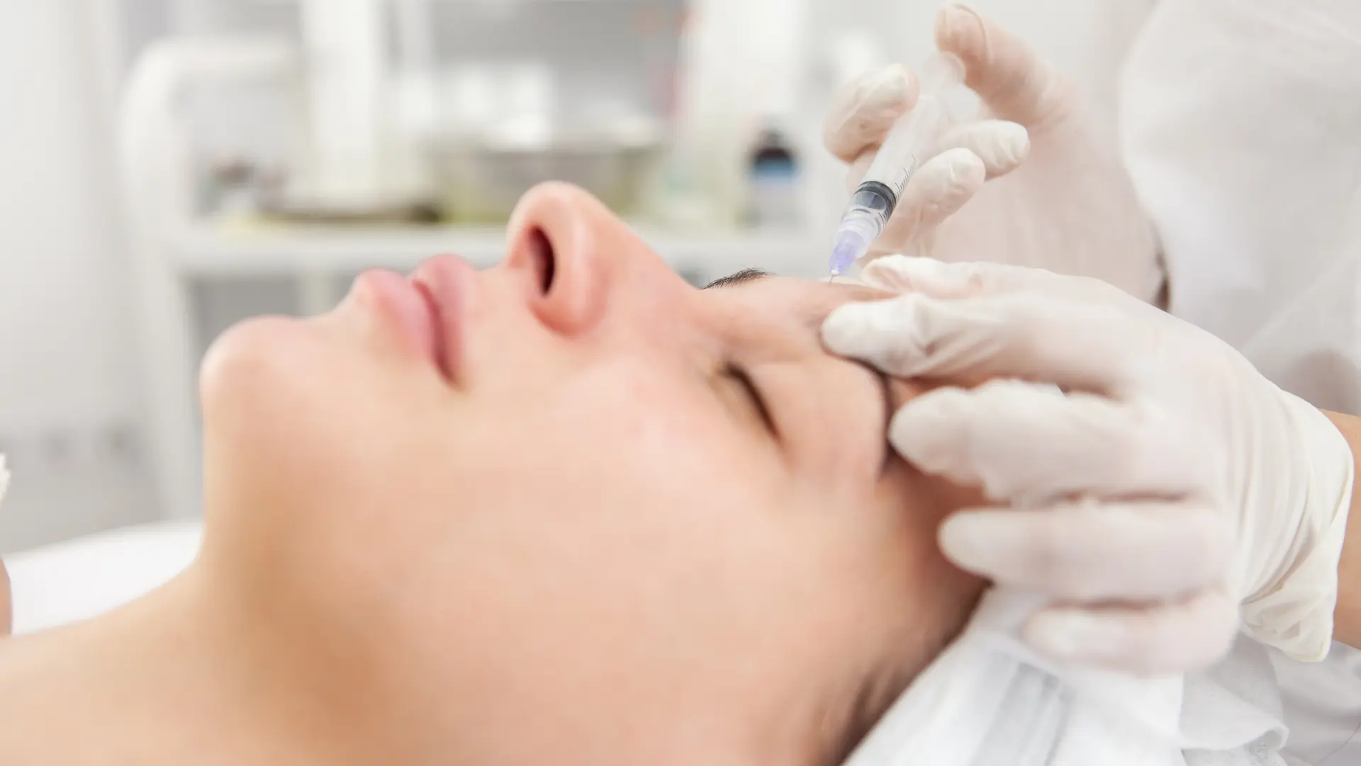An individual receiving an injection into their frown lines.