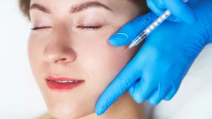 A patient receiving an injection into their mid-face region.